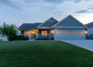 House with a two-car garage and exterior sconce lighting.