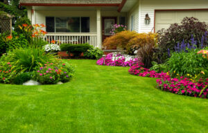 Manicured yard in the springtime with lush flowers and bright green grass.