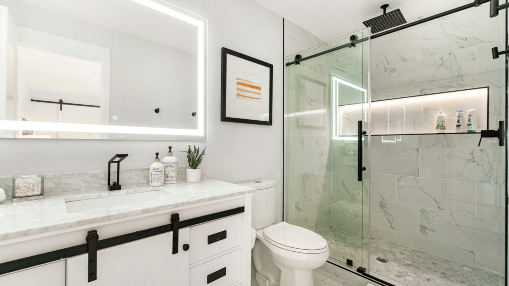 Luxury bathroom remodel with black accents and white tile.