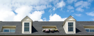 Shingle roof on a house with two dormers.