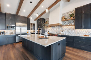 Recently renovated home kitchen with exposed ceiling beams and marble countertops.