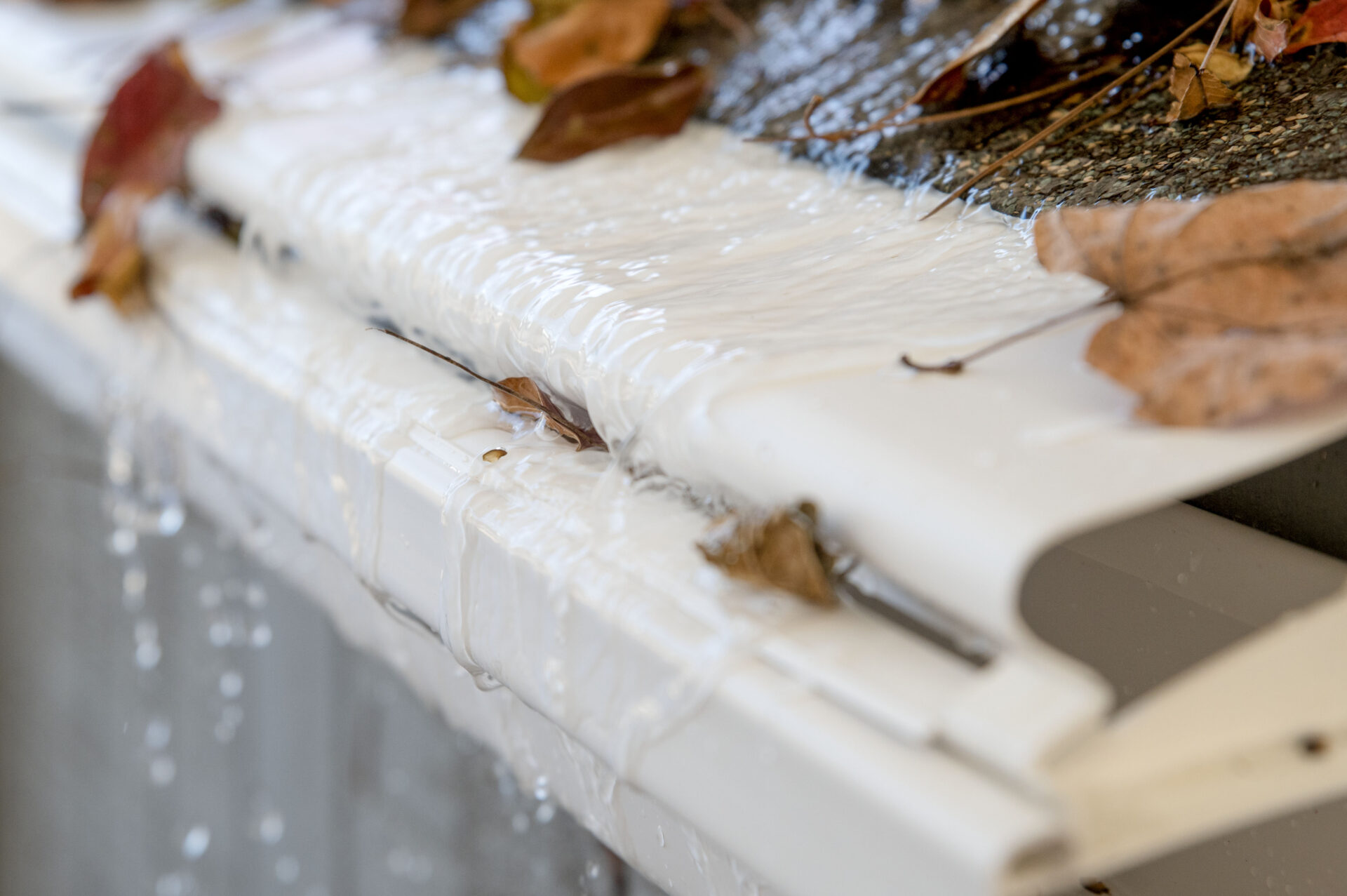 Water flowing over reverse-curve gutter guards.