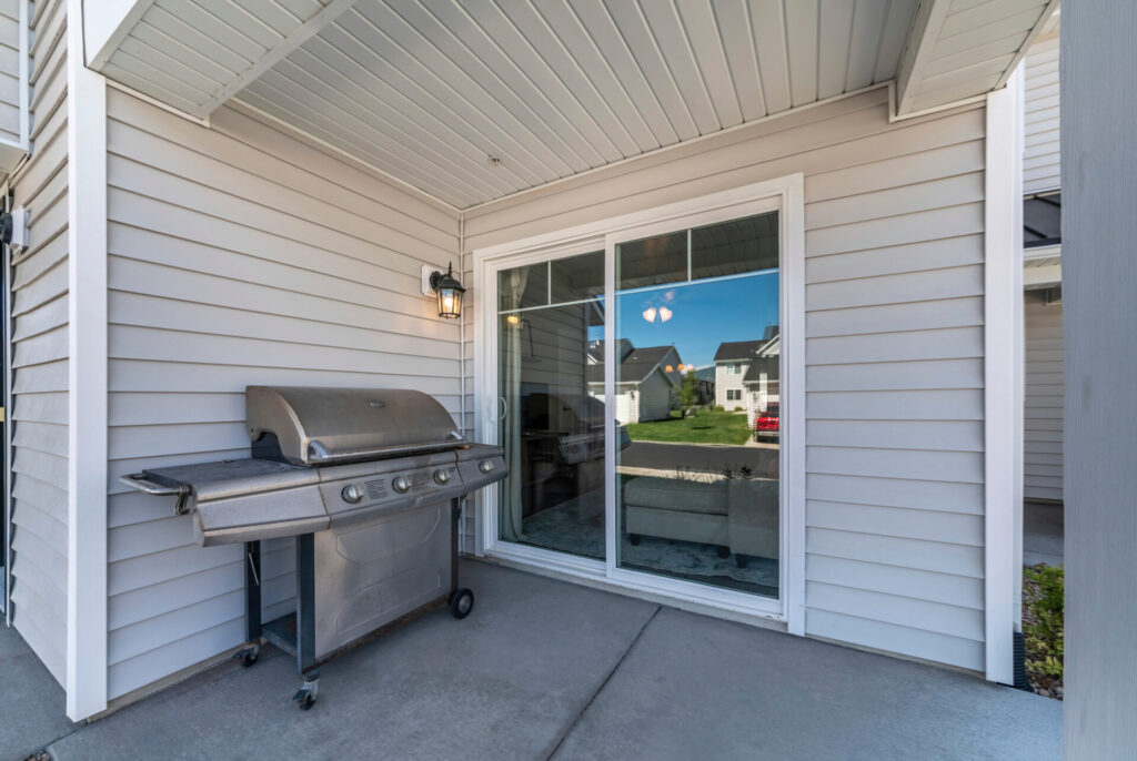 Porch with a vinyl sliding patio door and a gas grill