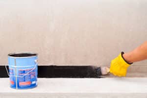 waterproofing a basement with a brush